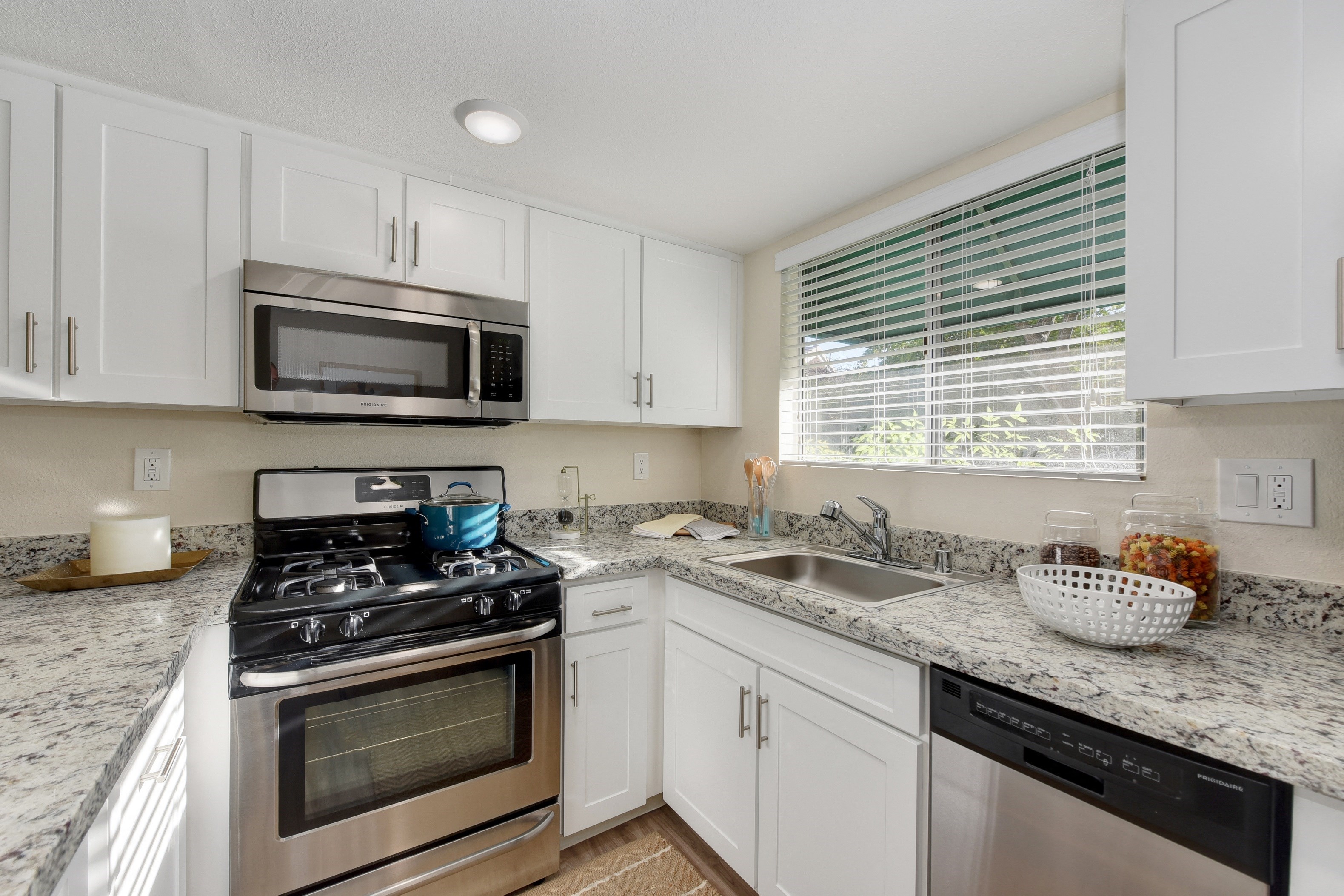 Kitchen with Granite Countertops, White Cabinets, Oven and Microwave